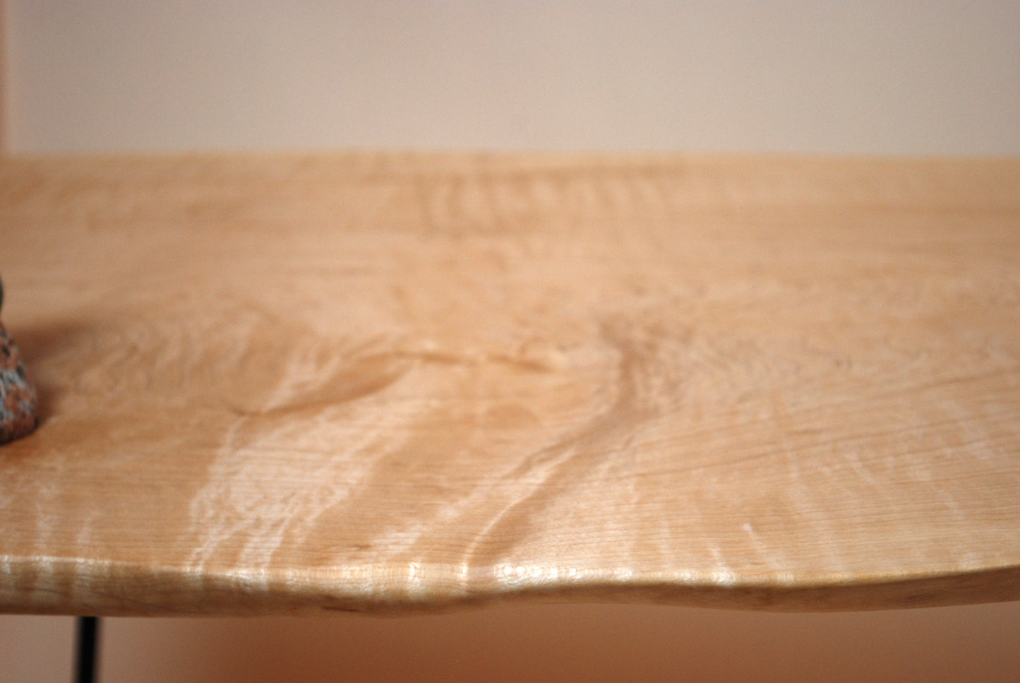 Figured maple coffee table with inset beach stones and hairpin legs