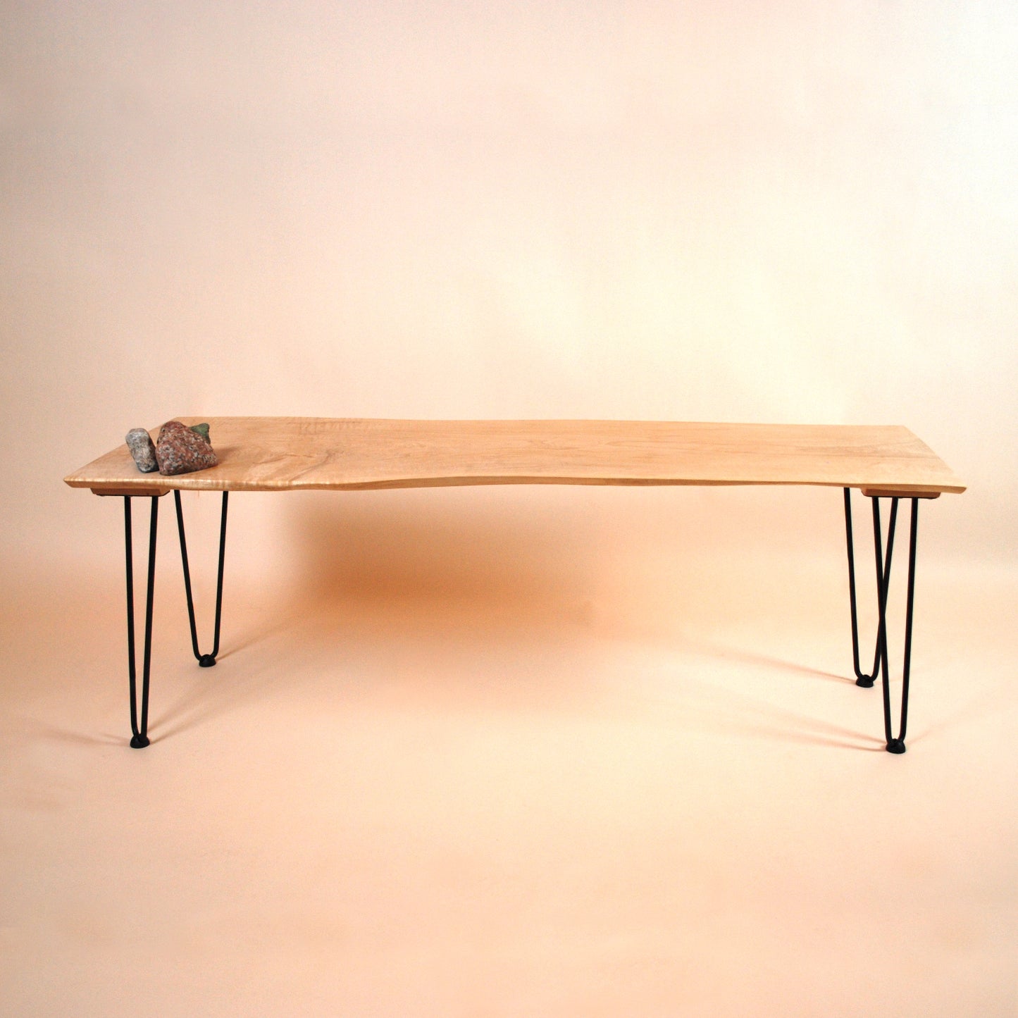 Figured maple coffee table with inset beach stones and hairpin legs