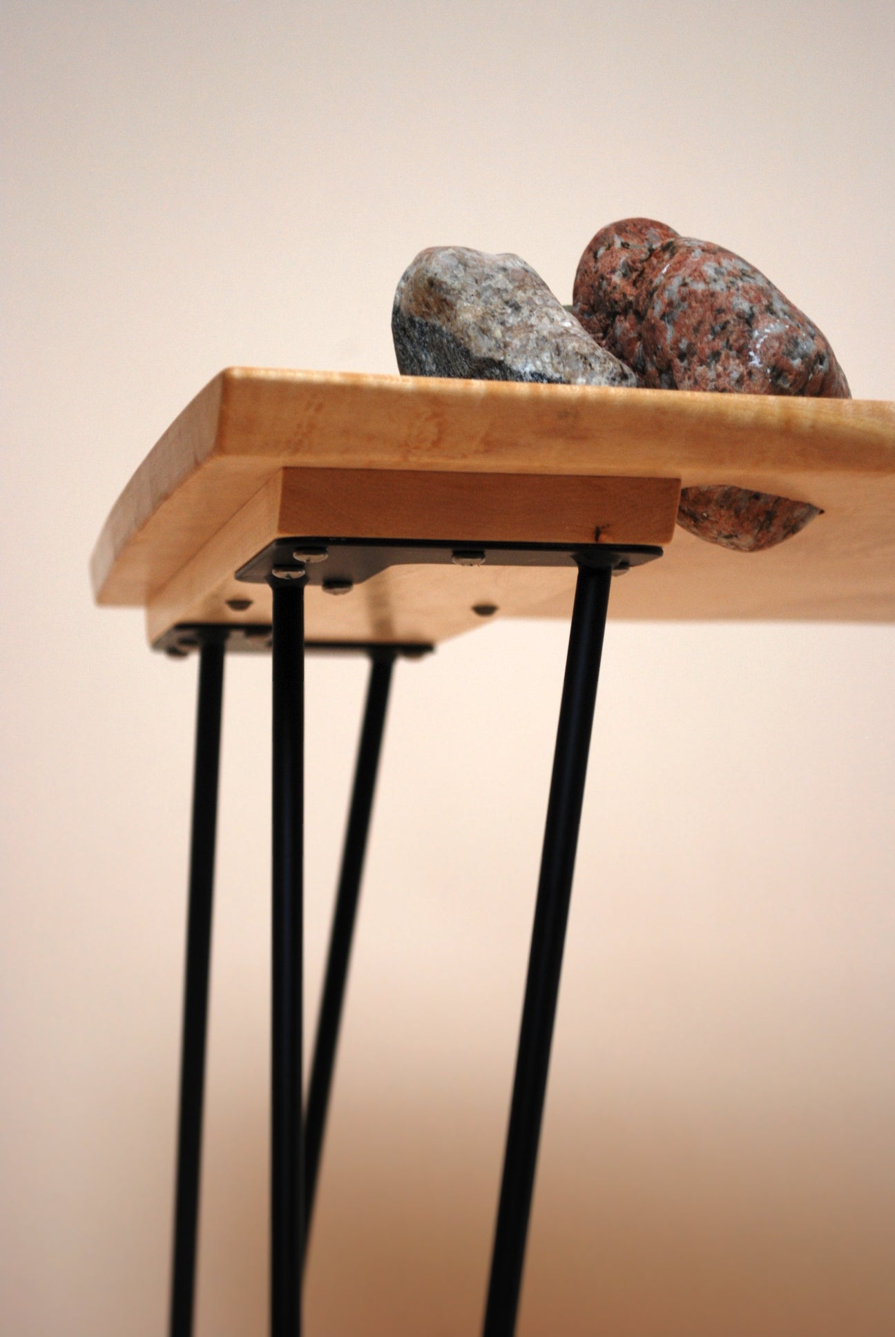 Figured maple coffee table with inset beach stones and hairpin legs