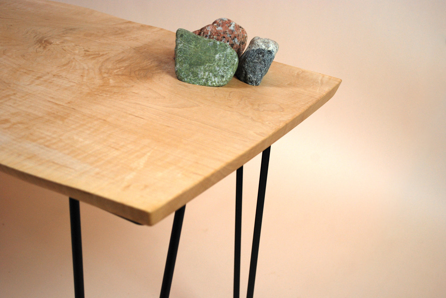 Figured maple coffee table with inset beach stones and hairpin legs