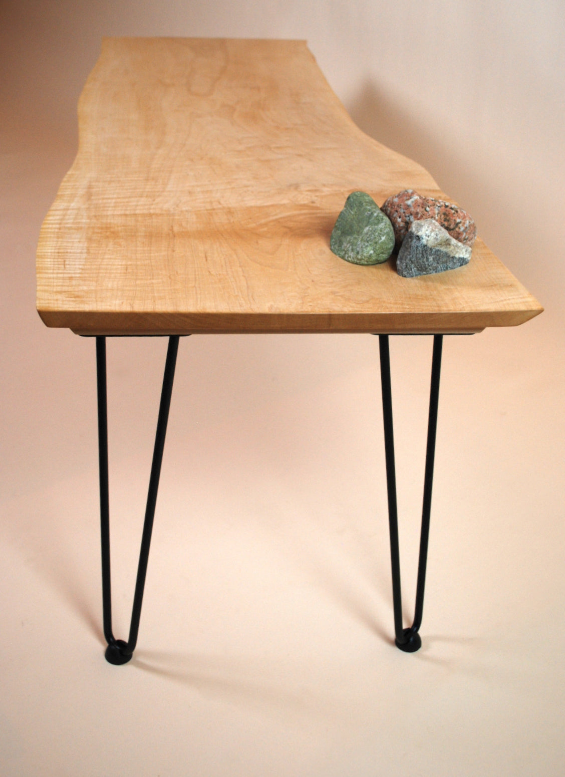 Figured maple coffee table with inset beach stones and hairpin legs